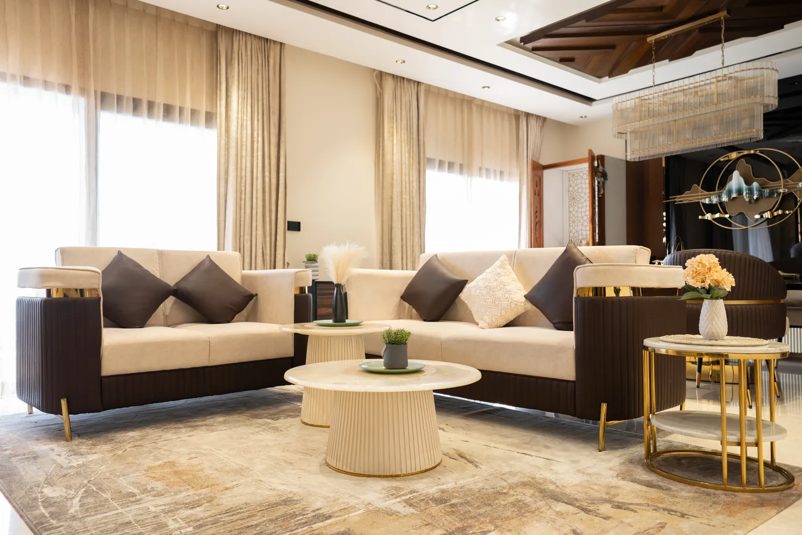 Living room with cream and charcoal sofas and gold side tables — Abhishek's Residence